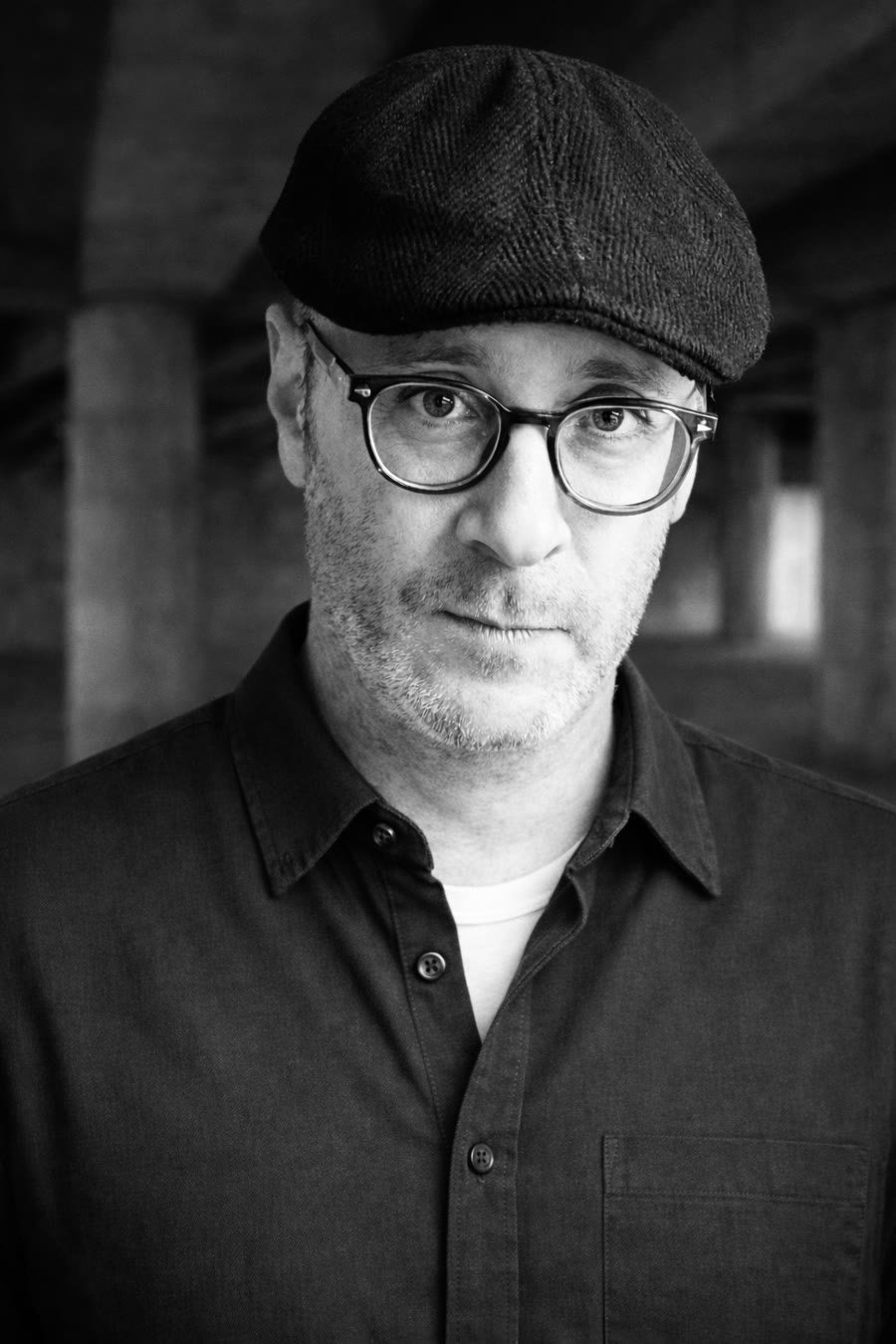 Portrait of Josh Beal in a flat cap and glasses